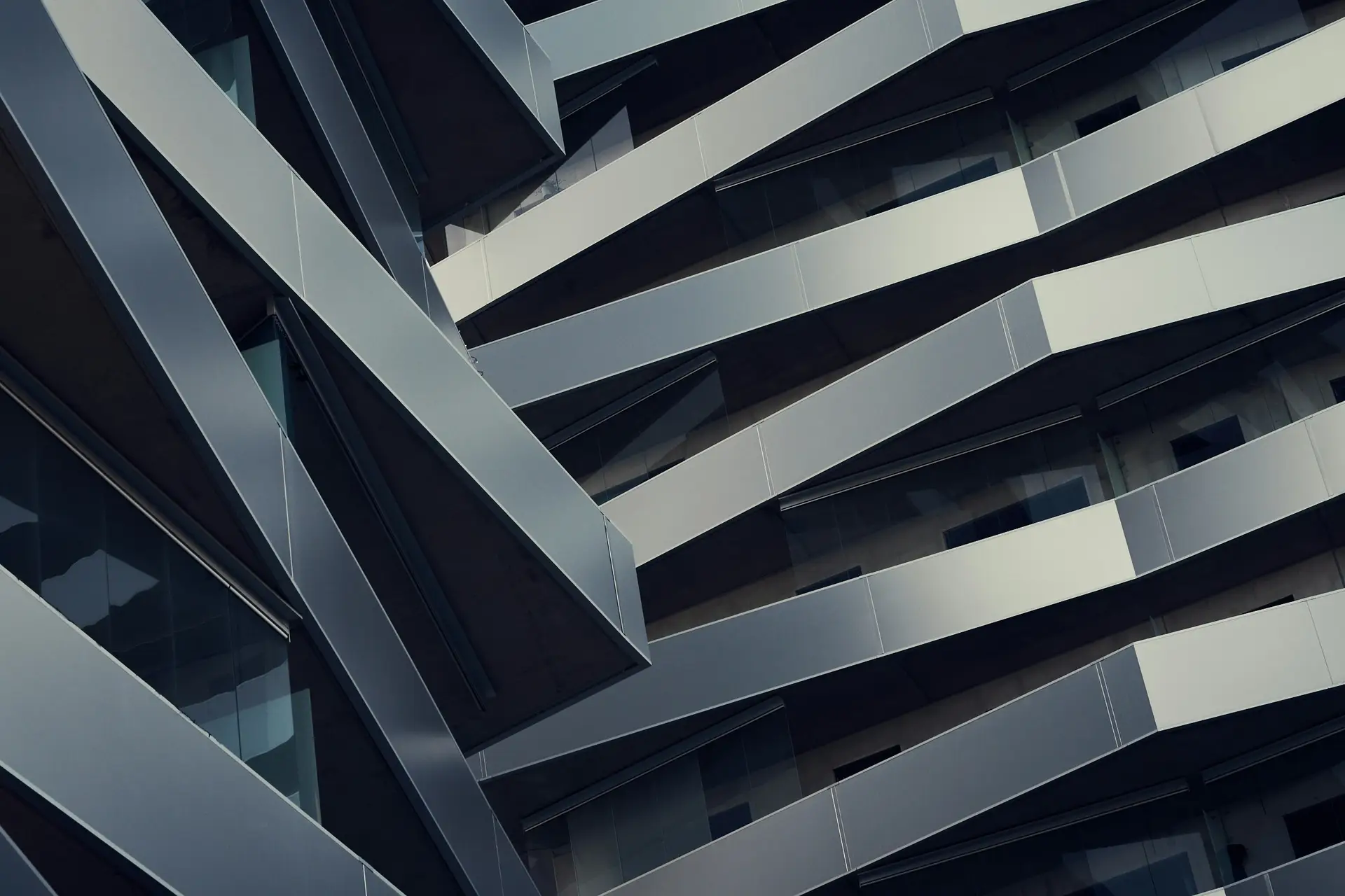 A tall building seen from the ground, its lines running up and out of view